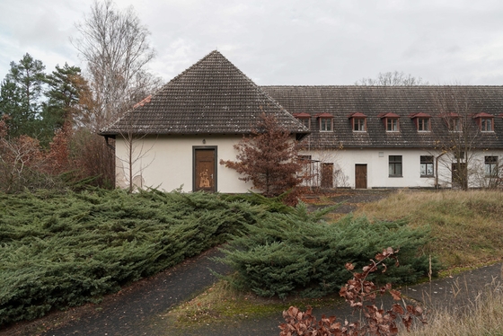 Gebüsch vor flachem Seitenflügel des Goebbels Waldhofes am Bogensee